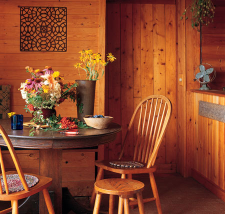 A brick floor in the dining area absorbs passive solar gain. Kate’s greenhouse is through the wood door.